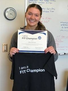 student smiling with certificate and t-shirt
